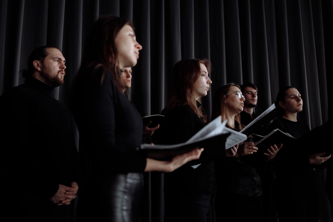 A singing group waits for instruction 