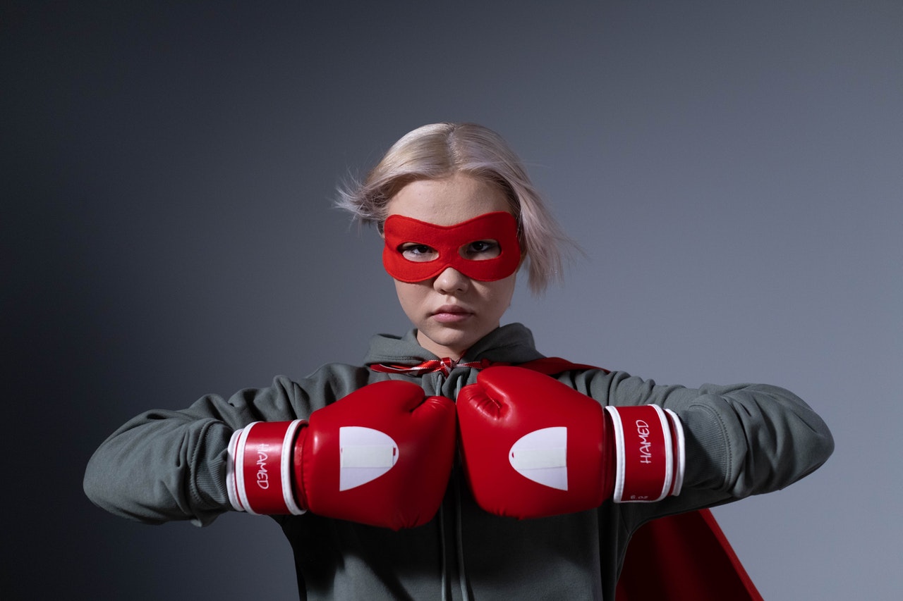 Girl with mask and boxing gloves is ready to fight her fears.