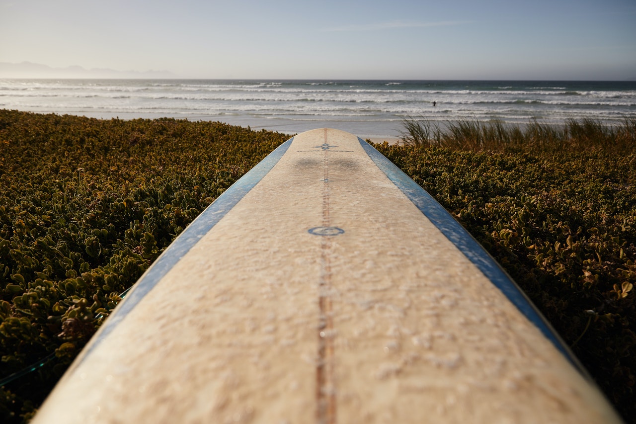Looking down a long surfboard towards the ocean invites a sense of vulnerability. 