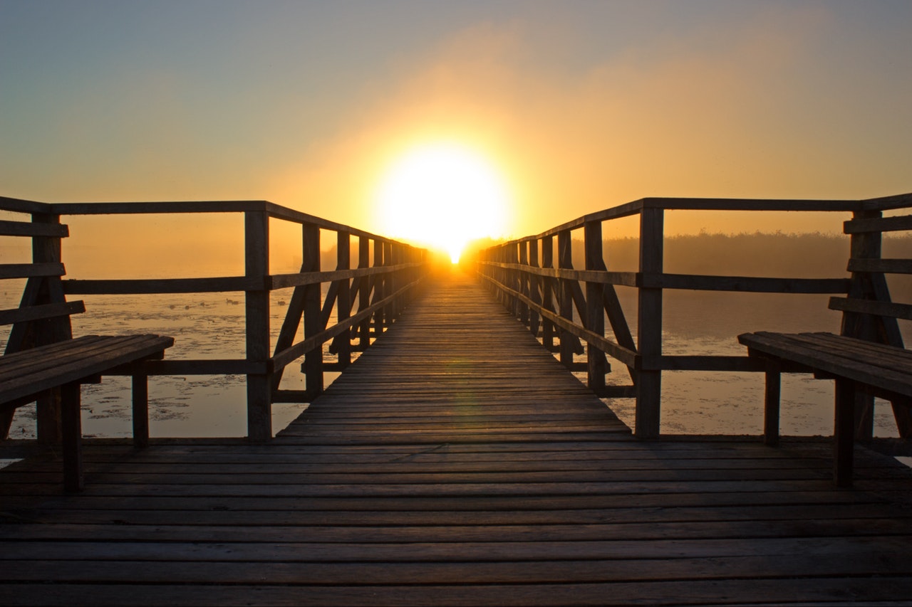 A look down a long dock facing the sun, representing the values we live by. 