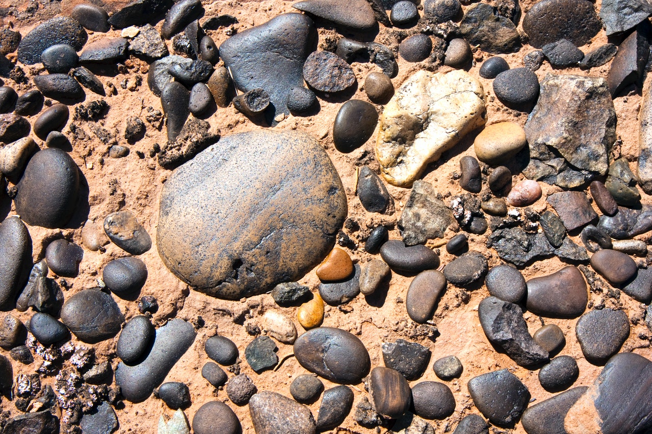 Another metaphor for a lifetime is a beach with wet rocks, pebbles, and sand